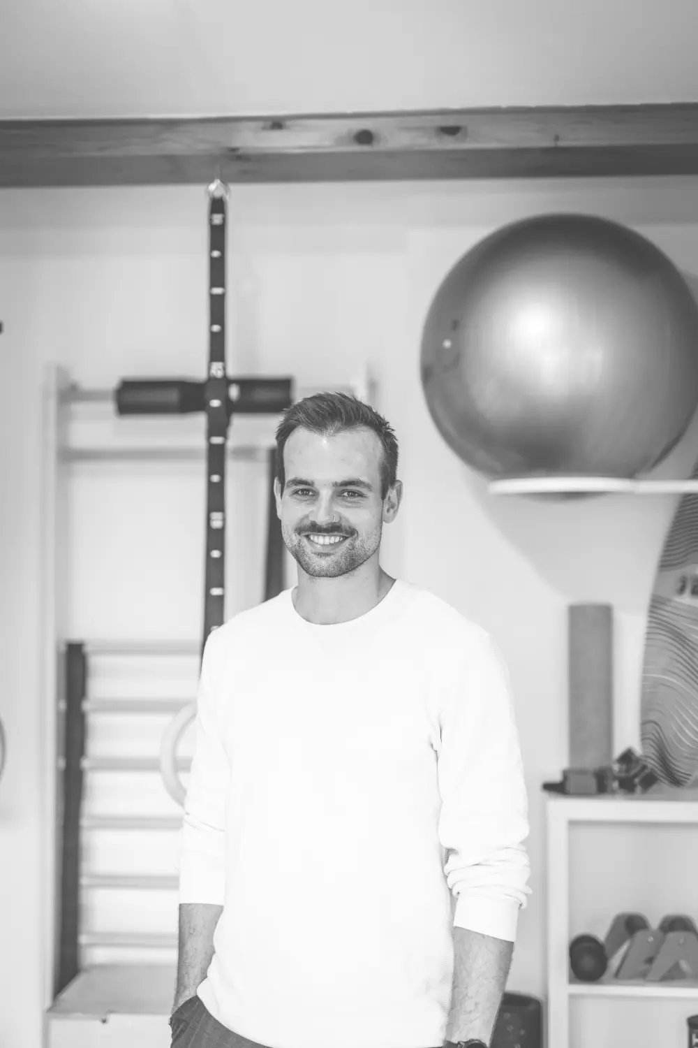 flow. Physiotherapie und Training – David Döbler und Gymnastikball im Hintergrund auf einem Regal